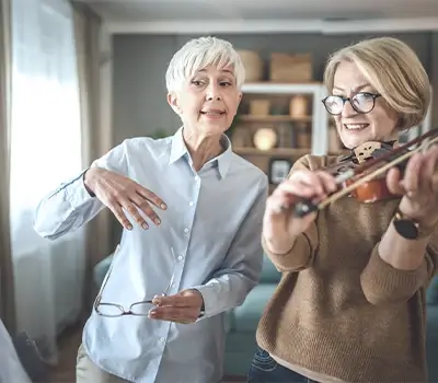 Zwei Frauen beim Geigespielen und Notenlesen