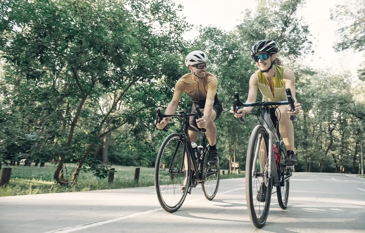 2 Personen mit Helm und Sportbrille auf dem Rennrad.