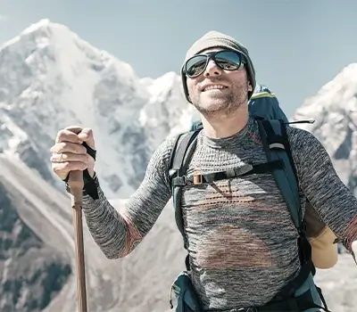 Ein Mann mit Sportbrille beim Wandern in den Bergen.